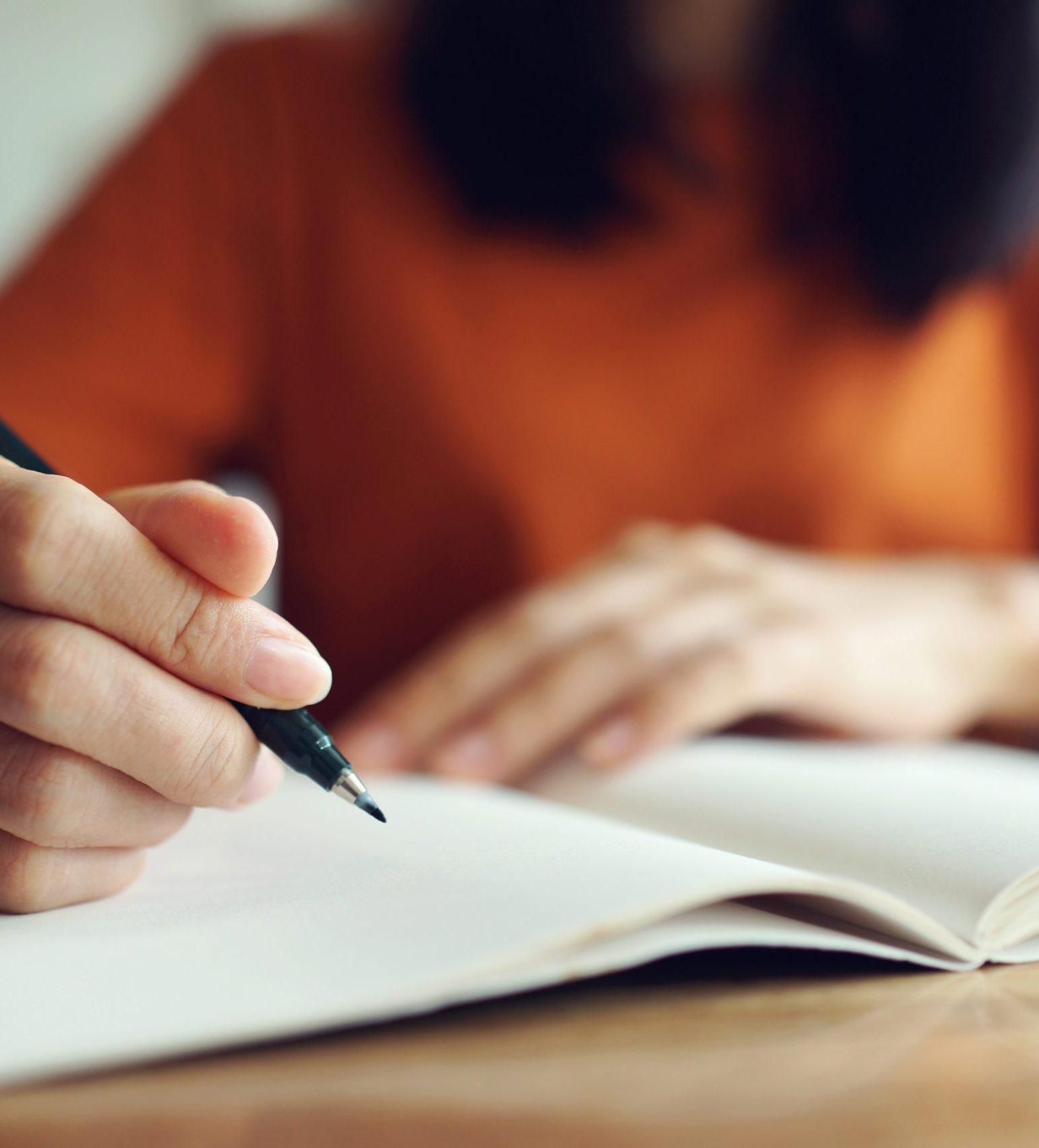 Close up woman hand writing on notebook .