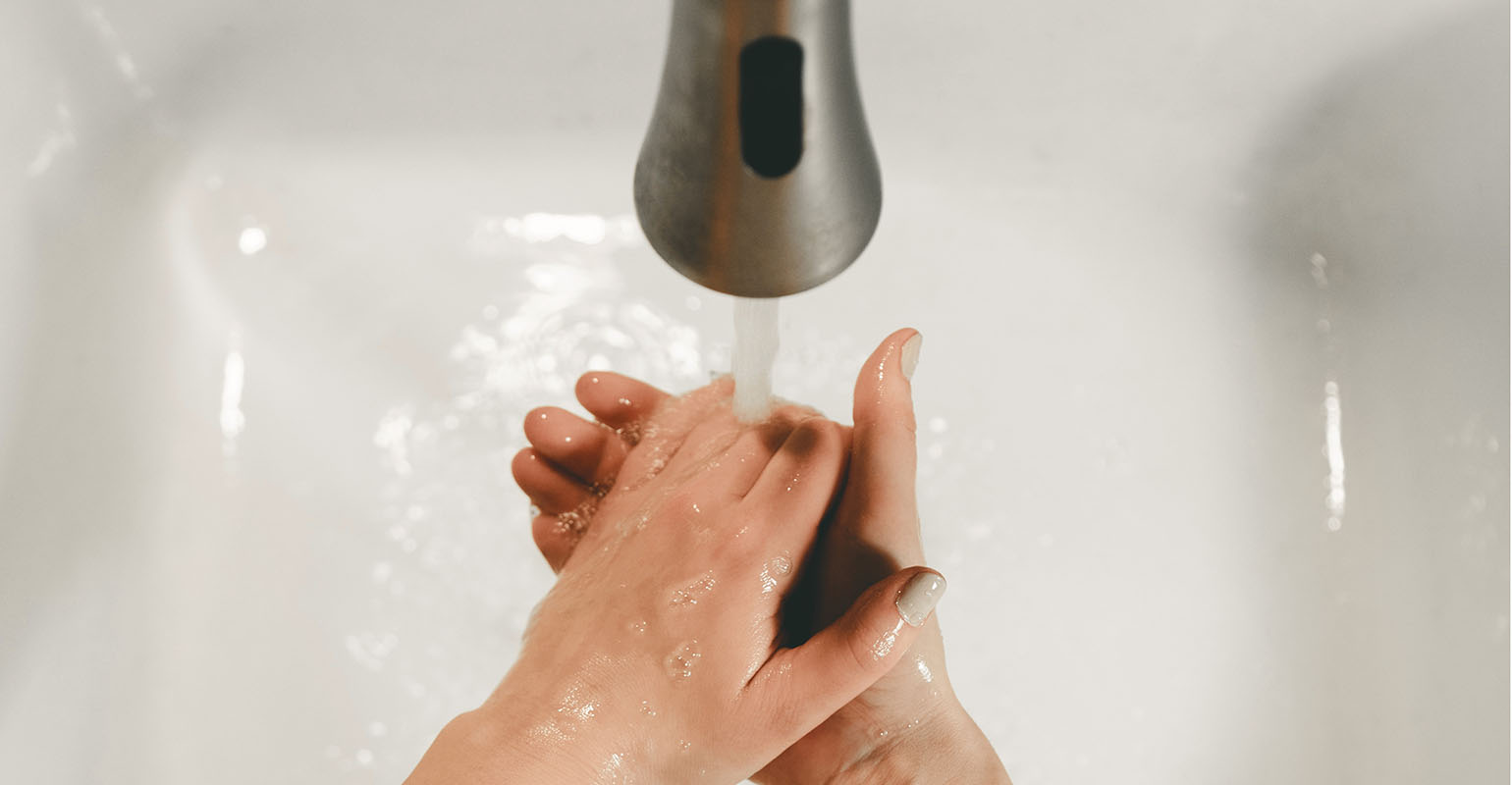 Person washing their hands in a sink